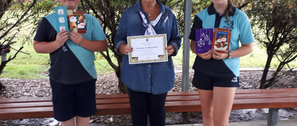 Joanne Heit (centre) passing on the thank you certificate to Flagstone Community School Captains.