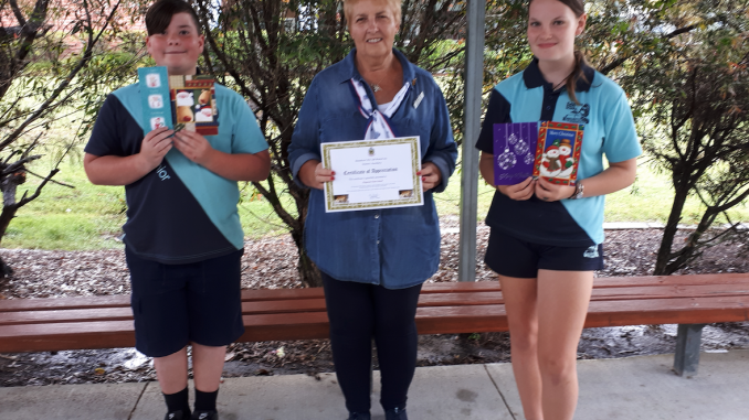 Joanne Heit (centre) passing on the thank you certificate to Flagstone Community School Captains.