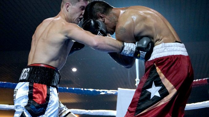 Dylan Biggs lays a punch on opponent Eddie De Santos. Photo: Neill Dickinson