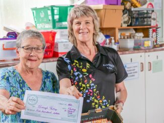 Judy Day from Tracey's Pantry accepts the donation from A Choired Taste's Karen Hardgrave