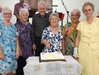 A celebration cake was cut by local Woodhill residents (L-R) Fay Dething, Jackie McCubbin, Robin Hopkins, Beatrice Flesser, Jill Ross, Glenys Beaman. Image Supplied.